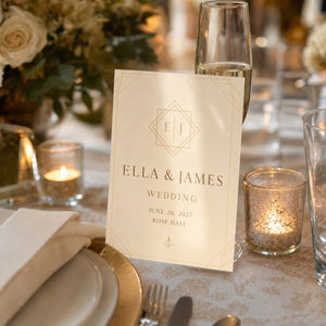 Glossy Invitations in use - propped against a champagne flute on a set wedding table with soft candlelight