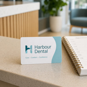 Plastic Business Cards in use - on a clinic reception desk beside an appointment book