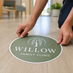 Anti-Slip Floor Decals in use - being pressed down onto a clinic floor by two hands