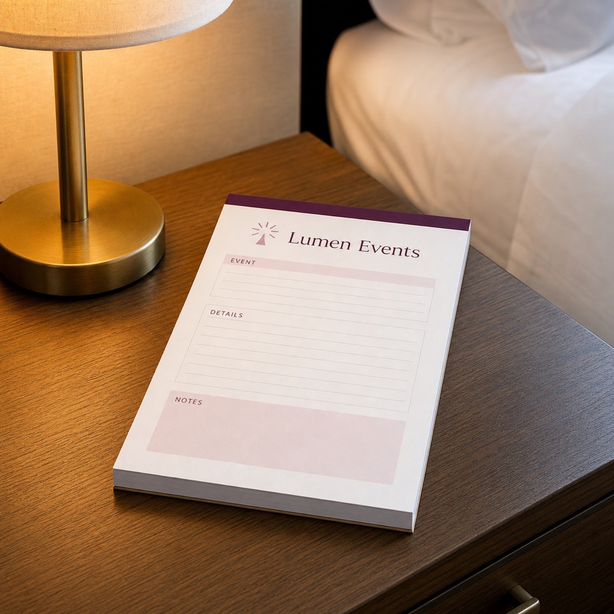 Custom Notepads (50 Pages) in use - on a hotel bedside table beside a lamp