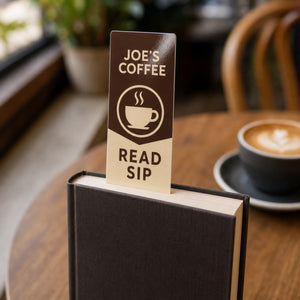 Gloss Laminated Bookmarks in use - sticking out of the top of a closed novel on a cafe table