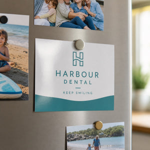 Glossy Postcards in use - pinned to a fridge door with a magnet among a few family photos