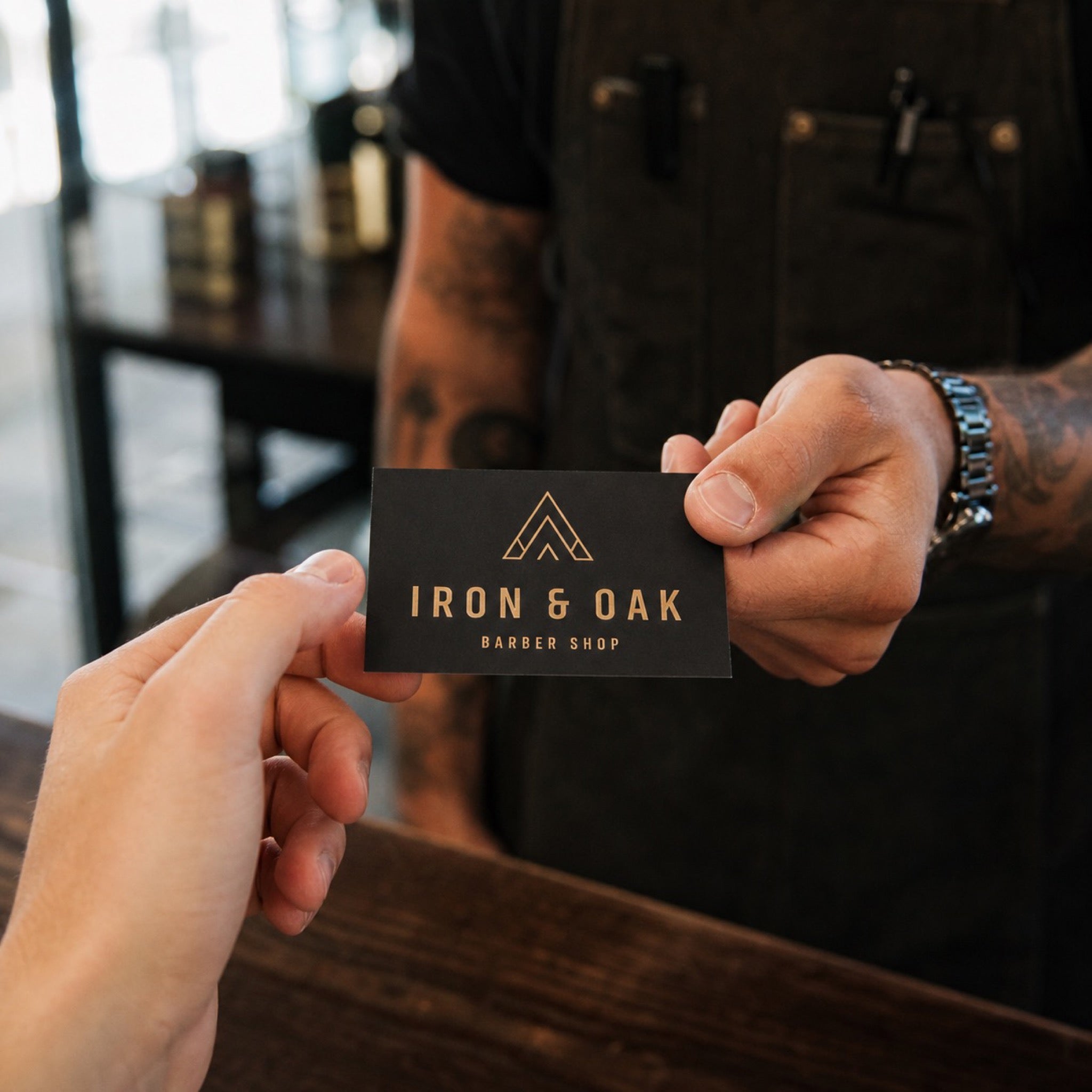 Premium Matte Business Cards in use - being handed across a workbench in a barber shop