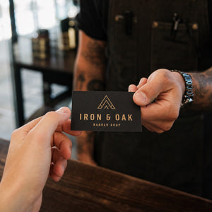 Premium Matte Business Cards in use - being handed across a workbench in a barber shop